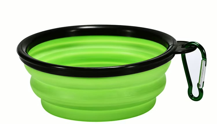 Green collapsible dog bowl with black rim and carabiner on a white background