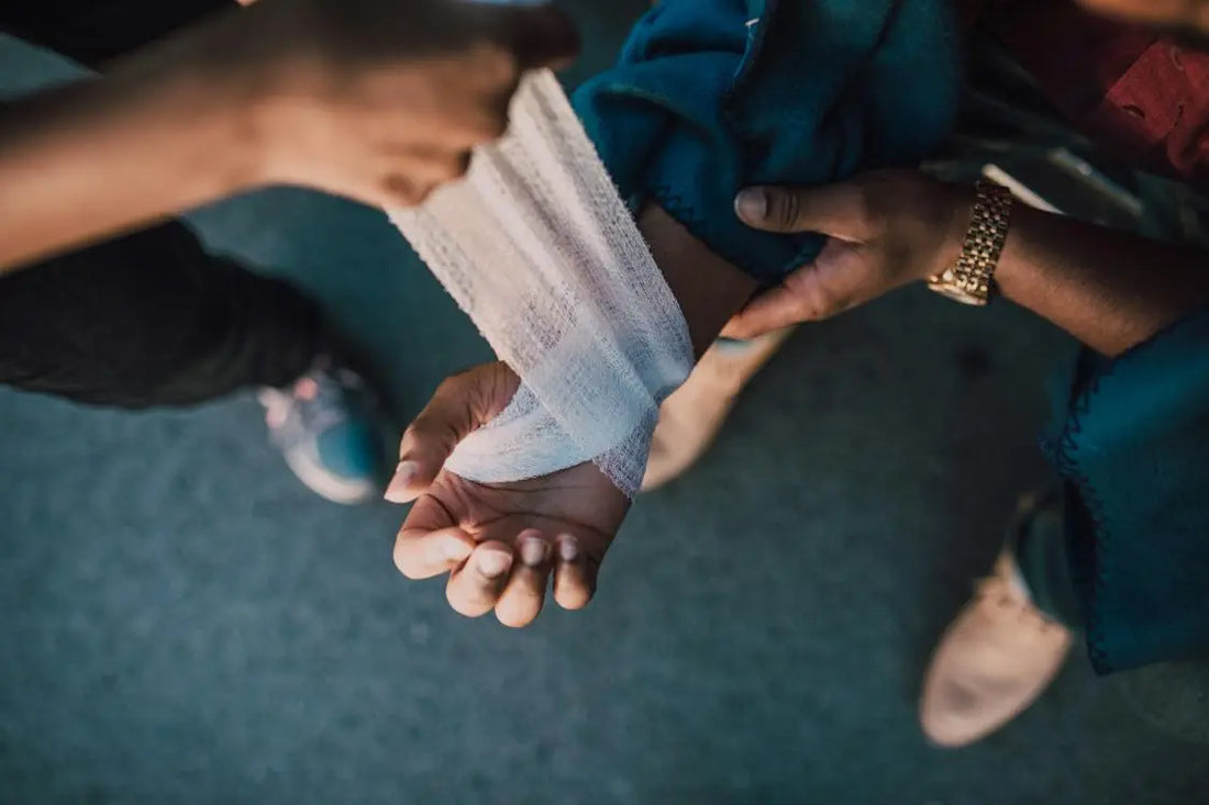 person putting bandage on other person's hand