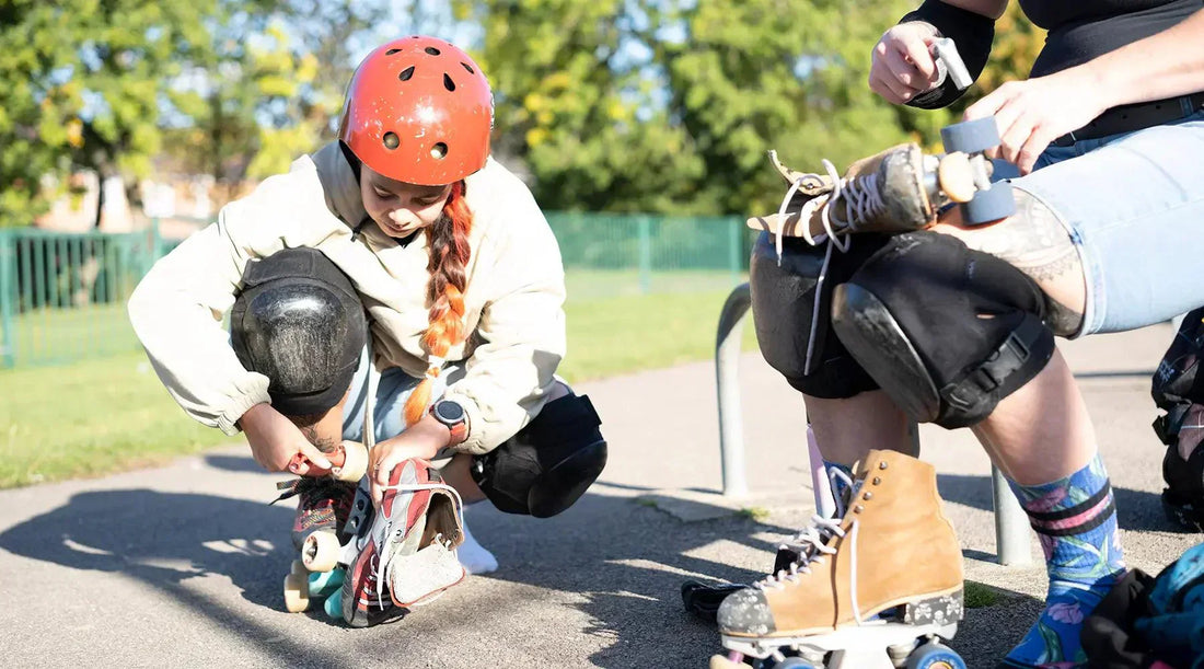 A person tying her roller skates.