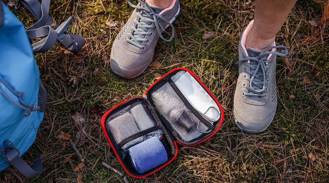 Person standing in grass with backpack and first aid kit.