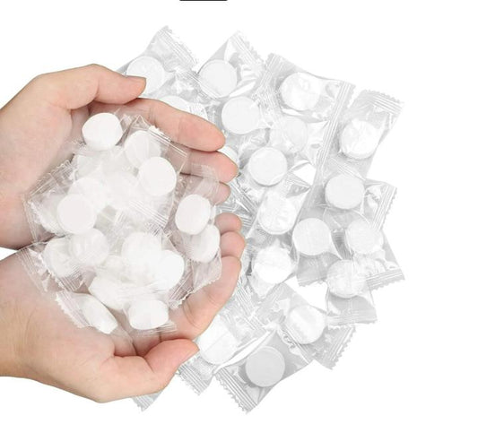 A person holding compressed dry towelettes , showcasing the product in their hands.