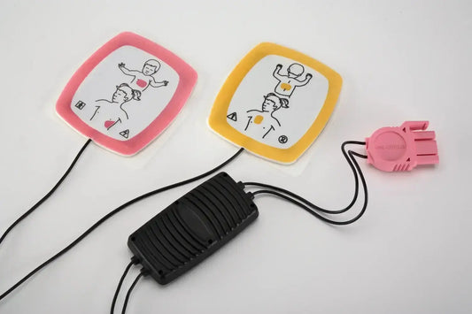 A defibrillator with two pads and a power unit on a white background